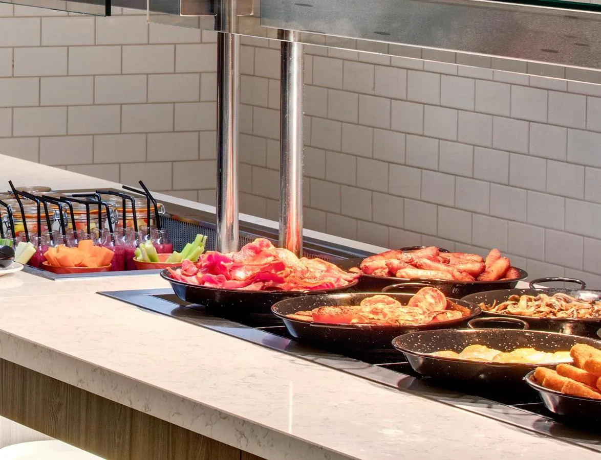 a buffet line with many different types of food in pans at Leonardo Hotel Newcastle Quayside in Newcastle upon Tyne