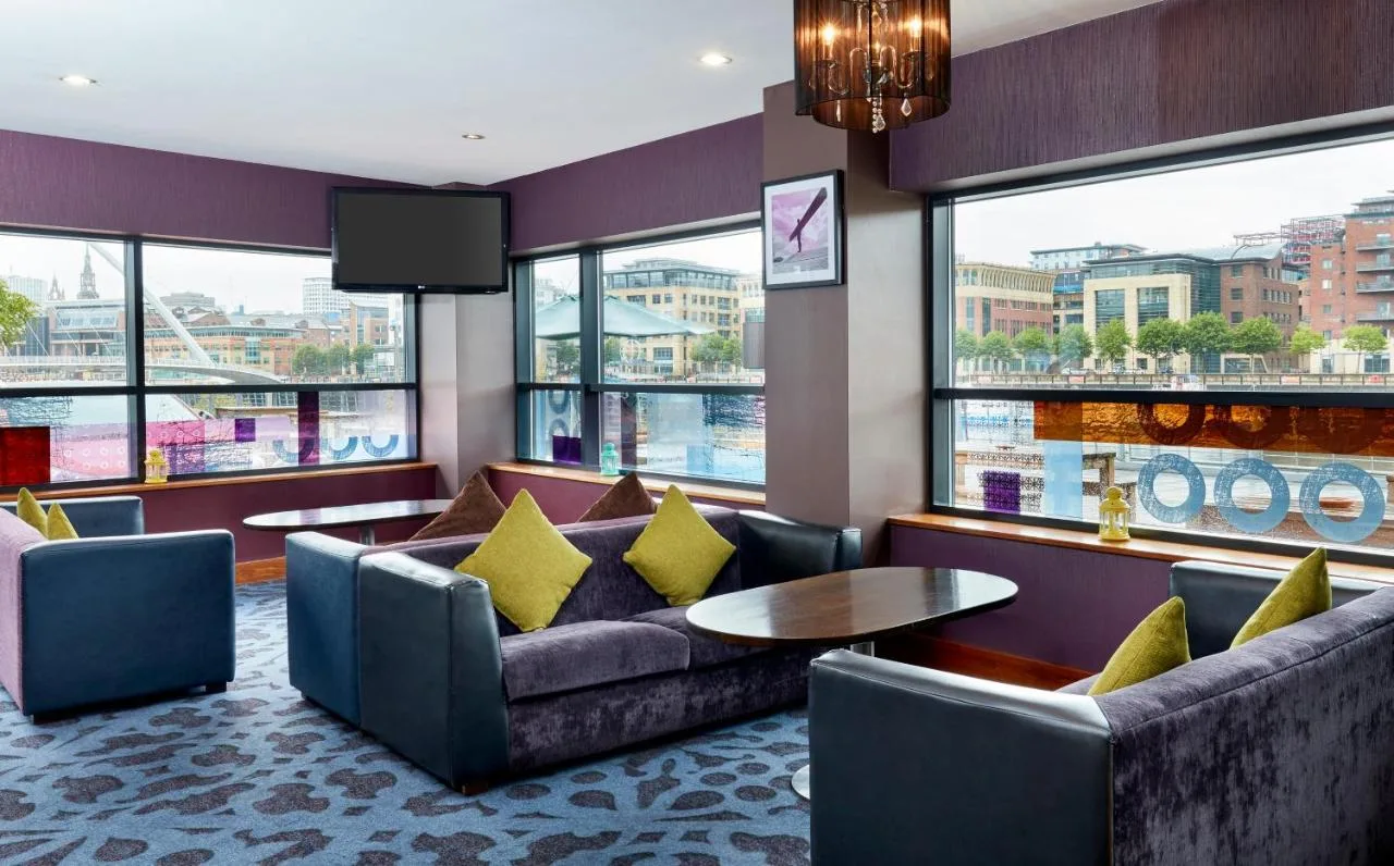 a hotel lobby with couches and a table at Leonardo Hotel Newcastle Quayside in Newcastle upon Tyne